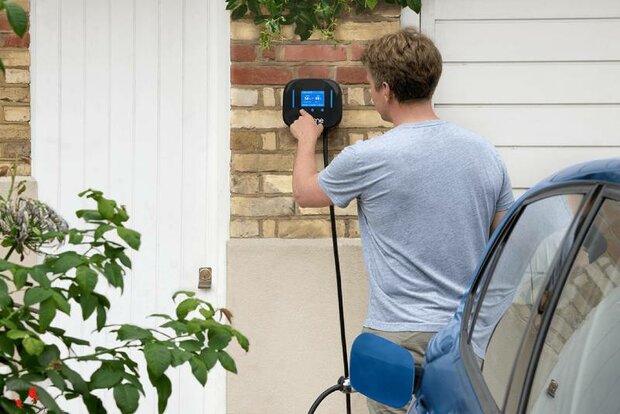 Een man die een Ohme Home Pro laadpaalbedient