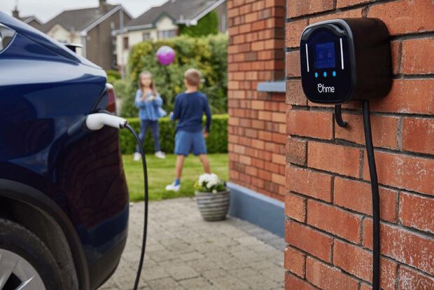 Ohme Home Pro laadpaal aan een stenen muur bevestigd