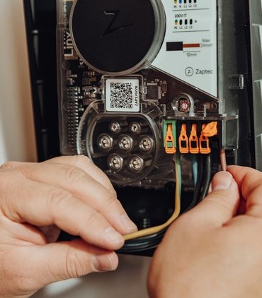 Zaptec Go lader, open, met handen van installateur erbij
